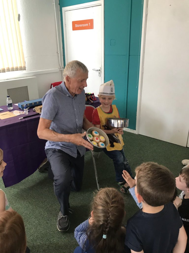 Man performing trick for children - doing the cake trick at Oscar's party