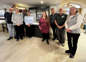 Athelstan Museum Coining It  - Some of the volunteers who have worked to bring the Malmesbury Coin Hoard to the Athelstan Museum, from left to right Graham McDougal,  Mike Goodyer,  Susan Mockler, Maria Marsh, Alan Taylor, Ruth Sandiford,  Mimzy and Anne Goodyer. 