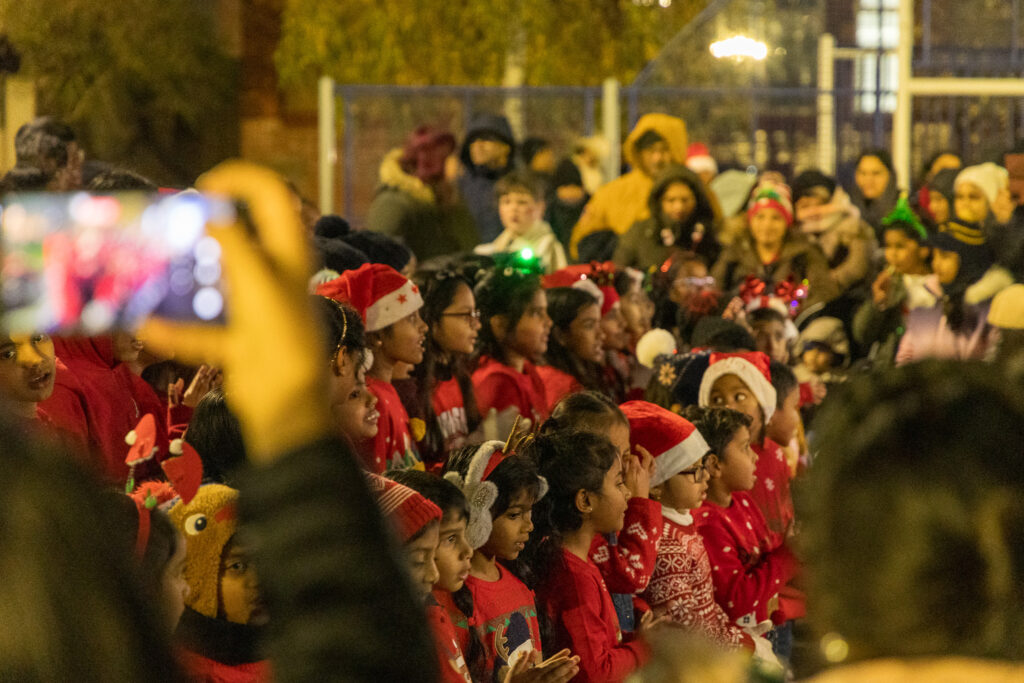 Children singing at Christmas tree community event