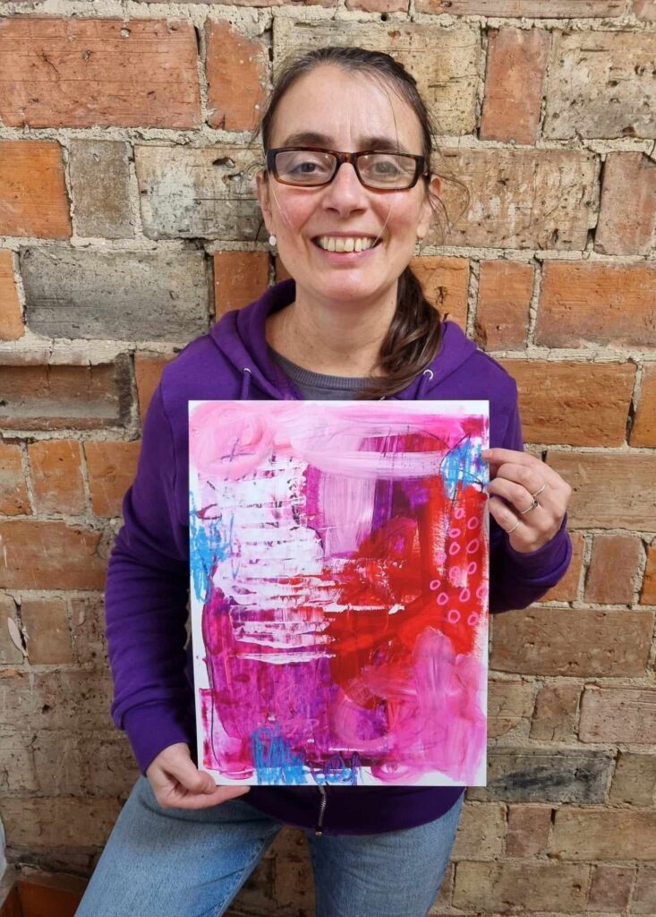 Helen Savin holding painting 
