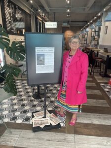 Angela Atkinson and poster in Fika coffee and wine